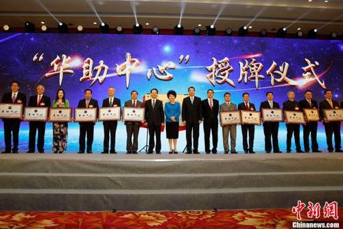中国侨网9月29日，国务院侨办主任裘援平（左八），党组书记、副主任许又声（左九）、副主任谭天星（左七）、副主任郭军（左十）为第四批15家“华助中心”授牌。当日，中国国务院侨务办公室、中国海外交流协会在北京举办“为侨服务日”活动，来自83个国家和地区的537位侨界代表及国内相关部门负责人共庆中华人民共和国成立68周年。中新社记者 李慧思 摄
