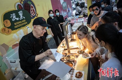 中国侨网6月9日傍晚,宁波老外滩,“舌尖上的相遇-中东欧美食与‘诗画浙江·百县千碗’人文交流活动”波黑美食展位上,主厨彼特·海瑞兹向消费者展示一道东欧甜点的配方。 中青报·中青网记者 李峥苨/摄