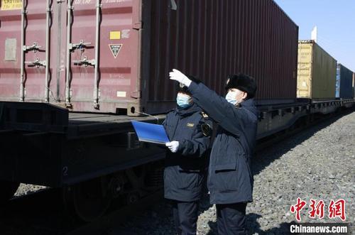 中国侨网哈尔滨海关所属绥芬河海关关员对进境中欧班列实施查验。　哈尔滨海关供图
