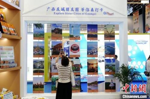 中国侨网9月17日,参展民众在广西国际友城进东博展区“打卡”。廖章利 摄
