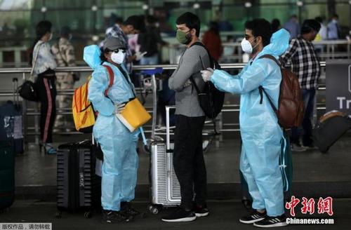 中国侨网5月25日，在印度孟买希拉吉国际机场，旅客们穿戴着防护服和面罩出行。 印度政府允许国内航线自5月25日起恢复。