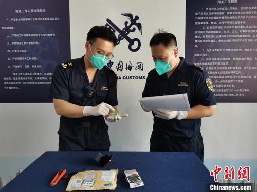 中国侨网图为北京邮局海关关员开拆邮包进行查验。　孟晨　摄