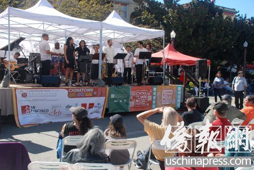 人们顶着烈日骄阳听歌唱表演。(美国《侨报》/吴卓明