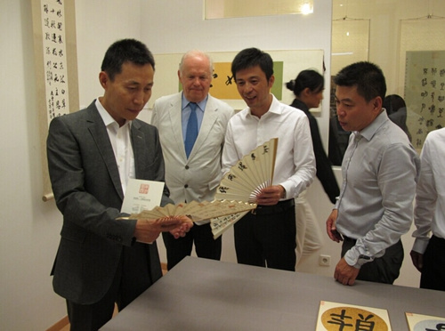中国驻奥地利大使馆文化参赞李克辛(左一)、奥中友协常务副主席卡明斯基(左二)在黄寿耀(右二)、策展人王星(右一)带领下参观展览。(法国《欧洲时报》)