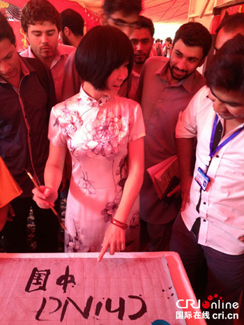 中国侨网国际台巴基斯坦广播孔子课堂教师向参观者展示书法文化。