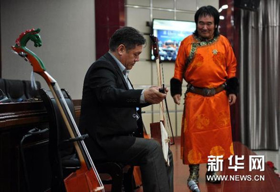 中国侨网一名蒙古国马头琴艺人（左）试拉潮尔（一种古老的马头琴）。（阿斯钢 摄）