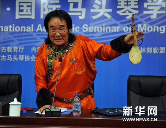 中国侨网著名马头琴演奏家齐·宝力高向与会者展示马头琴的前身——小奚琴。（阿斯钢 摄）