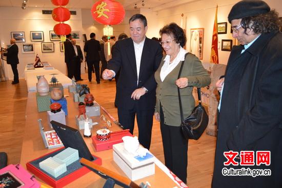 中国侨网郑国进参赞向嘉宾介绍中国文化工艺品情况。(文化部网站)