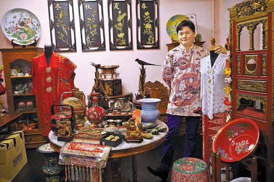 中国侨网黄俊荣向记者展示一个娘惹家庭的常见摆件，许多与中国传统习俗相似。