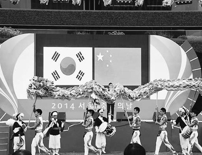 中国侨网伴随着韩国农乐铿锵的节奏,中国舞龙队精彩的表演深深吸引了当地观众。(万宇 摄)