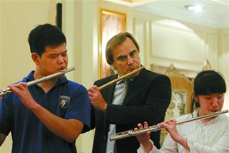中国侨网长笛演奏家安德烈·格里米内利（中）为盲童授课。（蒋迪雯 摄） 