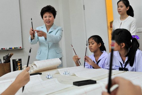 中国侨网图为初庆玲女士教泰国学生写书法。(高健钧 摄)