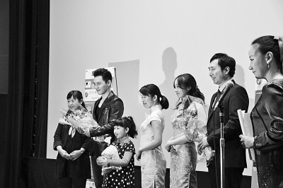 中国侨网图为《洋妞到我家》导演陈刚（右二）和小演员陈一诺在放映仪式上接受观众献花。（谢宗睿 摄）