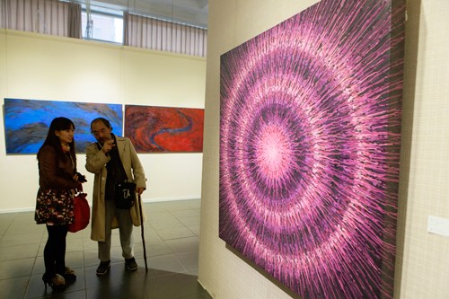 中国侨网一位观众指着参展中国艺术家孟禄丁的油画作品《元速》说：“我以前见过这幅作品！它给我留下了很深的印象。”（法国《欧洲时报》/李旭 摄）