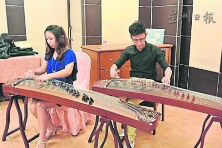 中国侨网黄诘雯(左)与王定天在新闻发布会现场演奏经典古筝乐曲。(马来西亚《星洲日报》)