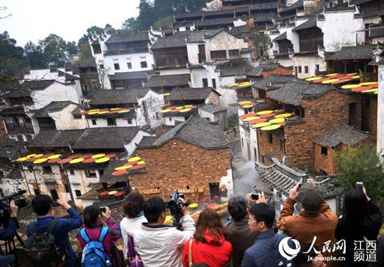 中国侨网婺源篁岭景区迎来外媒记者,他们被眼前的美景吸引,和游客一起拍摄欣赏古村落美景。