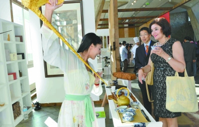 中国侨网身着传统汉服的茶艺师王霏向外国朋友展示茶艺。(张全能 摄)