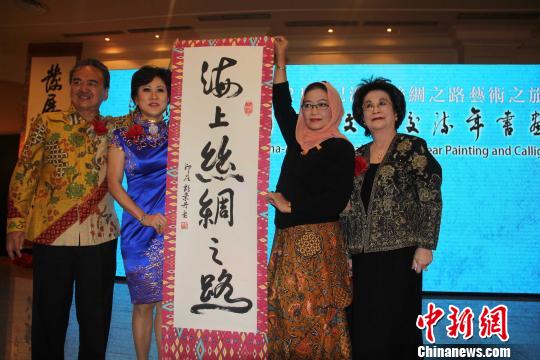 中国侨网12月6日,为庆祝2014年中国东盟文化交流年,中国-东盟书画家联合总会6日至7日在雅加达举行“21世纪海上丝绸之路艺术之旅”书画大展。中国-东盟书画家联合总会辅导主席胡素丹(左2)赠送书法作品给印尼教育文化部与电影辅导主席爱迪玛(右2)。(顾时宏 摄)