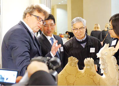 中国侨网图片说明:陶艺大师周国桢（左三）向英国观众介绍陶瓷艺术品《任重道远》。