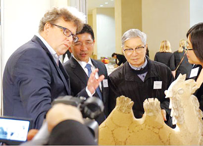 中国侨网图片说明:陶艺大师周国桢(左三)向英国观众介绍陶瓷艺术品《任重道远》。