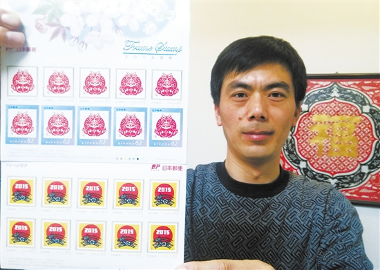 中国侨网图为张建中展示票面为其剪纸作品的日本邮票。(纪哲 摄)
