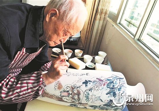 中国侨网郑福生克服种种困难,在德化白瓷上画老虎。(陈晓东 摄)