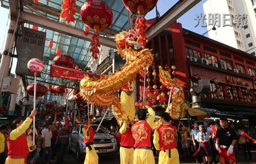 中国侨网春意渐浓的茨厂街在大清晨迎来舞狮舞龙队伍,为2015年农历新年敲起了春的祝福。(马来西亚《光明日报》)