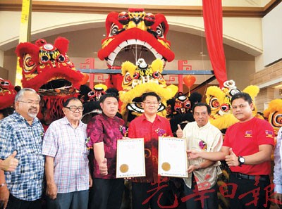 中国侨网林万锋(右3)展示全马最大狮王的大马纪录大全证书。(马来西亚《光华日报》)