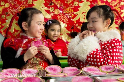中国侨网在山东省沂源县一家幼儿园，小朋友在吃萝卜“咬春”。 (赵东山 摄)