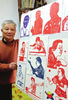 中国侨网剪纸艺人章维伟正在展示他的作品:“为乒乓世界冠军剪影”。作品上每一个人物的头发、服饰图案甚至皱纹均清晰可见,表情、打球动作也栩栩如生。(杭兴微 摄)