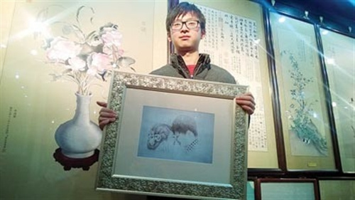 中国侨网张雪展示他创作的私人订制婚庆素描刺绣。(赵征南 摄)