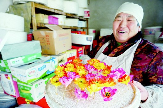 中国侨网李瑞英展示她做的四季花面塑,她的面塑远近闻名,不少人慕名前来学艺,远的传到了韩国。(韩逸 摄)
