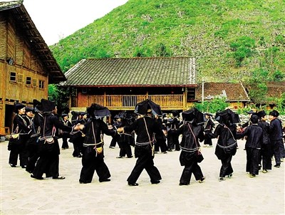中国侨网黑衣壮们围在一起跳舞。