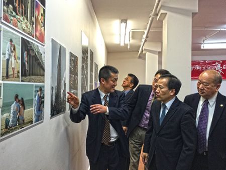 中国侨网周焕新(左一)向大家介绍摄影作品。(美国《侨报》)