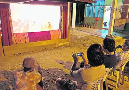中国侨网大家在露天下欣赏皮影戏。（马来西亚《星洲日报》）