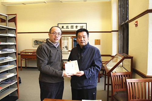 中国侨网冰凌向耶鲁东亚图书馆中文部主任孟振华（左）赠送101岁中国文豪马识途和他三哥、104岁老作家马士弘的签名著作。（姜卫国 摄）