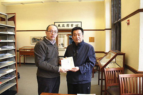 中国侨网冰凌向耶鲁东亚图书馆中文部主任孟振华(左)赠送101岁中国