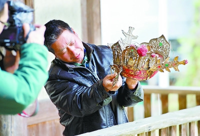 中国侨网福建省大田县阳春村的村民展示“肉身坐佛”遗失前所戴帽子。