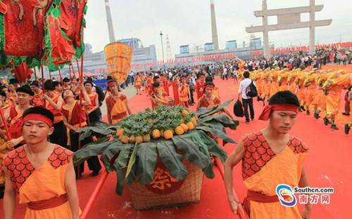 中国侨网“波罗诞”千年庙会的现场表演，演员们抬着菠萝巡游。（李细华 摄）