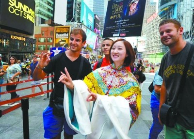 中国侨网北京京剧院梅兰芳京剧团的演员在美国时代广场与游客互动交流,推介京剧艺术。(王雷 摄)