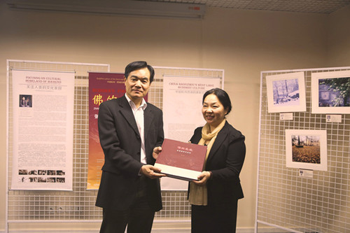 中国侨网陈一辉主席向张晓贝总裁赠送作品集。(法国《欧洲时报》/孔帆 摄)