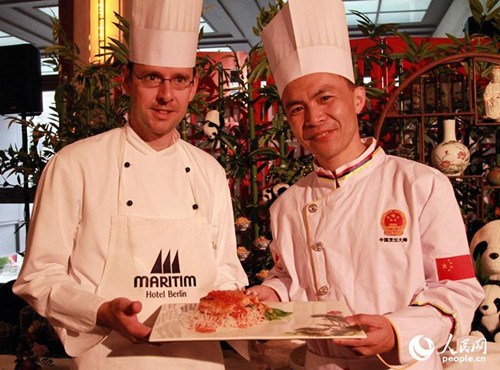 中国侨网中德两国厨师合作烹饪了一道“豆瓣三文鱼”,象征着中西文化交流互鉴。(管克江 摄)