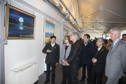 中国侨网黄建南(左一)向来宾介绍自己的作品。(法国《欧洲时报》/黄冠杰 摄)