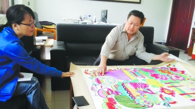 中国侨网康英勤向记者展示其年画作品。(曹斌 摄)