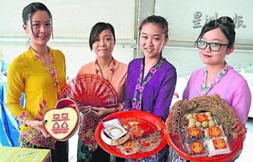 中国侨网美娘们向来宾展示土生华人婚嫁仪式上所采用、代表吉祥的物品及食品。（马来西亚《星洲日报》）