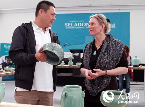 中国侨网毛伟杰（左）向穆安娜介绍龙泉青瓷优秀作品。（管克江 摄）