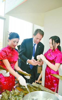 中国侨网6月20日，世博会意大利国家馆秘书长法布里奇奥·格里洛在学包粽子。（颜斌 摄）