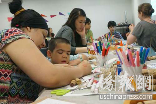 中国侨网参与家长与孩子一起制作龙舟。(美国《侨报》/陈辰 摄)