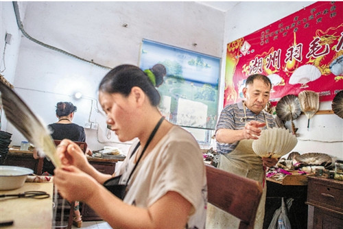 在湖州羽毛扇厂简陋的车间里,工人在制作羽毛扇