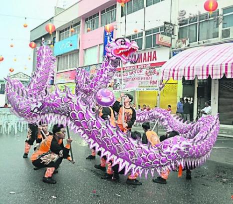 游行沿途中有舞龙表演助兴。（马来西亚《星洲日报》）